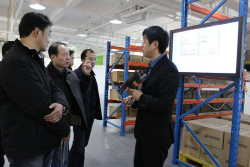 利奧創新科技工作人員正在向吳肇明處長等人講解RFID二維倉庫系統的功能特點